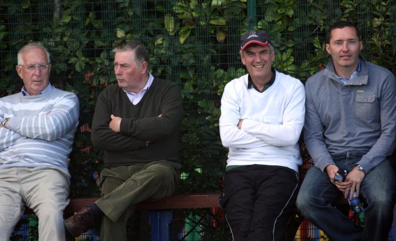 Supporters on bench by fence