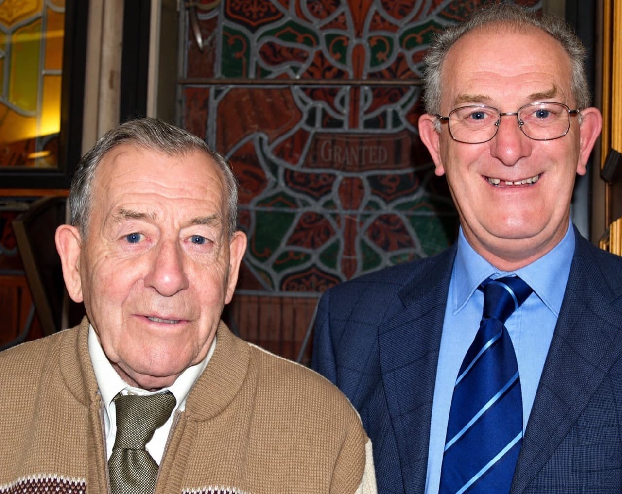Two friends pictured together indoors, from the photographs shared in memory of Reg Hargan